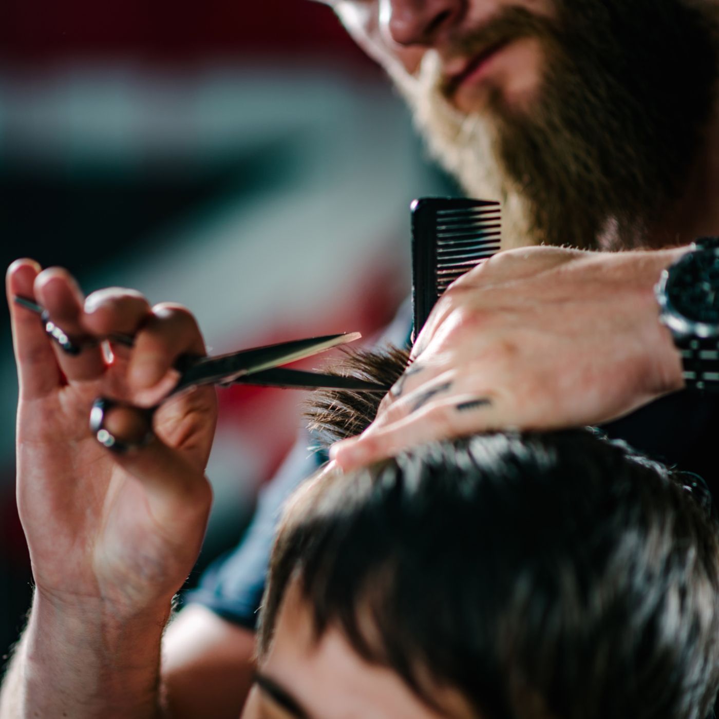 Barbier professionnel taillant une coupe aux ciseaux en salon